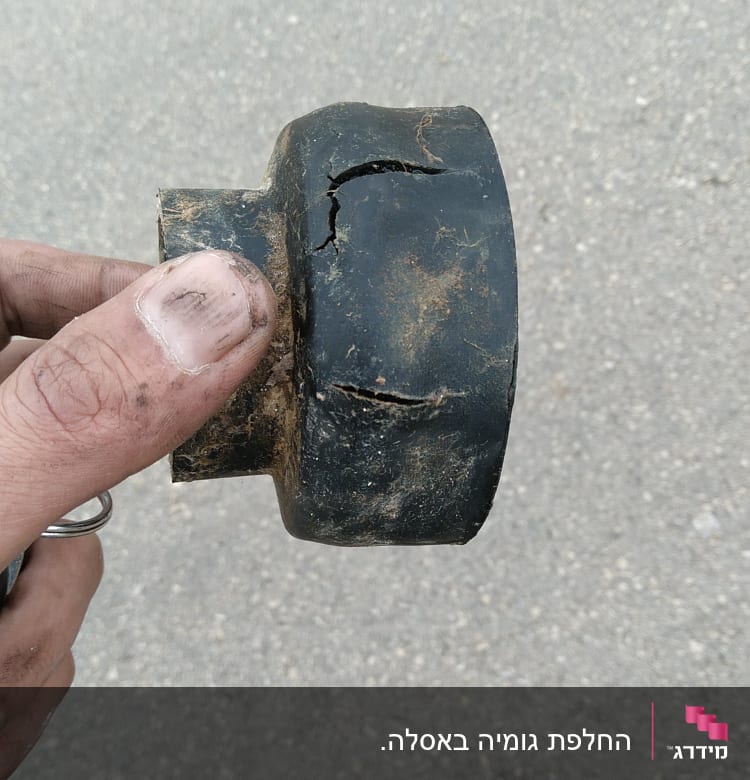 חלק צנרת שבור מוחזק ביד מלוכלכת